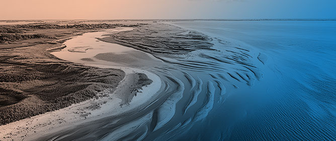 Influence of Long Jetties on Coastal and Estuarine Hydro-Sedimentological Patterns in a Microtidal Region: Potential for Mud Deposit Formation